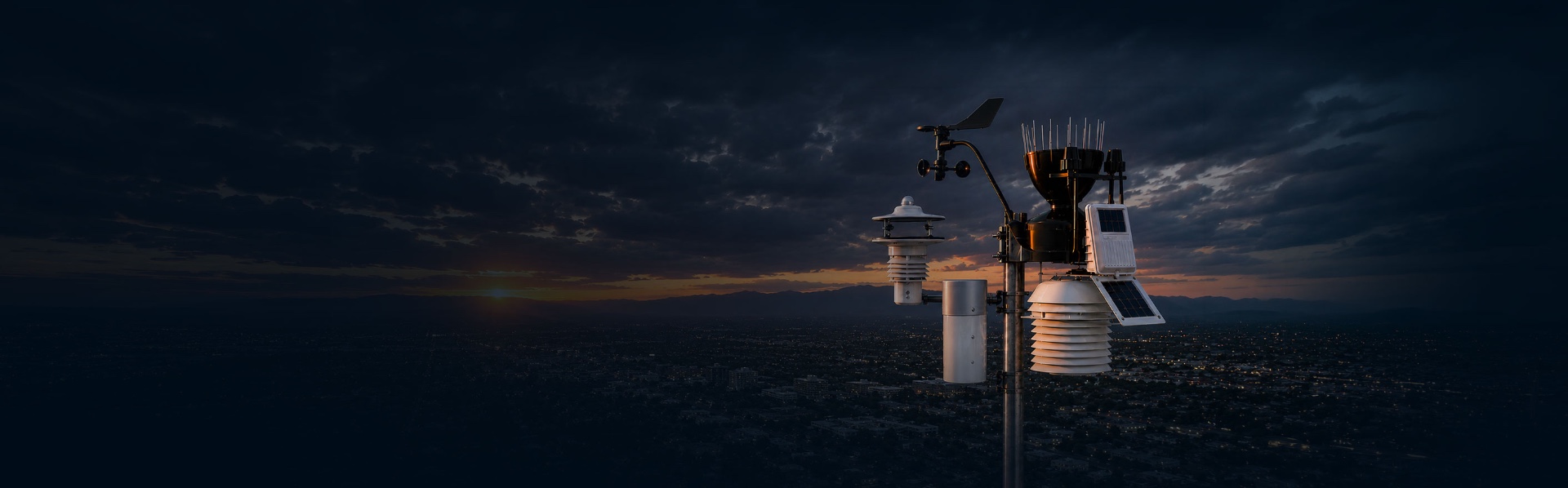 Weather station overlooking a city at dusk under dramatic storm clouds